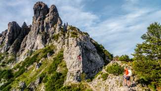 Zwei Wanderer auf dem felsigen Bergpfad bei den Drei Schwestern in Liechtenstein entlang der Route 66 mit markiertem Kletterabschnitt