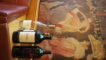 Drei Weinflaschen vor einem kunstvollen Wandgemälde in der Brasserie Burg