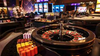 Eleganter Roulette-Tisch mit Jetons und Kugel im stilvollen Innenbereich des Casino Admiral Triesen. Eleganter Roulette-Tisch mit Jetons und Kugel im stilvollen Innenbereich des Casino Admiral Triesen.