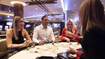 Freundliche Atmosphäre am Spieltisch: Drei Gäste unterhalten sich mit der Croupière im stilvoll eingerichteten Casino Schaanwald.
