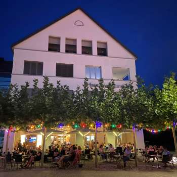 Stimmungsvolle Abendaufnahme des St. Martins Pub mit beleuchteter Terrasse und bunten Lichterketten.