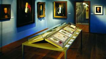 Fürstenzimmer im Liechtensteinischen LandesMuseum mit Exponaten im Hintergrund