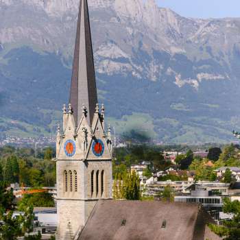 Blick auf die Kathedrale St. Florin in Vaduz mit Bergen im Hintergrund