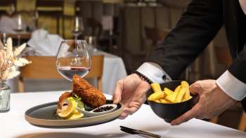 Serviertes Gericht mit paniertem Fleisch und Pommes Frites in moderner Präsentation im Restaurant Alpspitz.