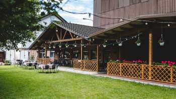Großzügige Terrasse des Bangshof mit Holzelementen, hängenden Pflanzen und gemütlicher Atmosphäre