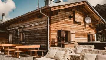 Gemütliche Sonnenterrasse des Sareis Bergrestaurants mit Holzbänken und Alpenpanorama