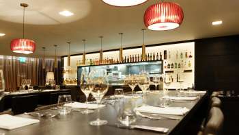 Moderne Bar im Restaurant Kokon mit stilvollen Weingläsern und stimmungsvoller Lichtgestaltung