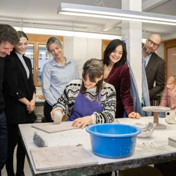 Eine Gruppe interessierter Besucher beobachtet eine Töpferin beim Modellieren – Kreativerlebnis in gemütlicher Atmosphäre in der Keramikwerkstatt Schädler in Nendeln.