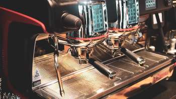 Kaffeemaschine im Restaurant mit glänzender Edelstahloberfläche und roten Akzenten