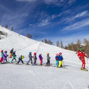 Skilehrer im Malbi-Park Malbun motiviert Kinder auf dem Übungshang – perfekte Umgebung für die ersten Schwünge im Schnee.