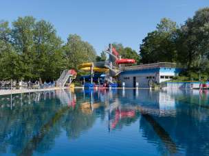 Schwimmbecken mit Wasserrutschen und Badehaus im Freibad Mühleholz in Vaduz