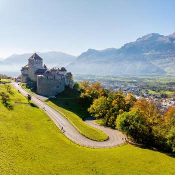 Schloss Vaduz auf einem Hügel mit Blick auf das Rheintal und umliegende Berge.