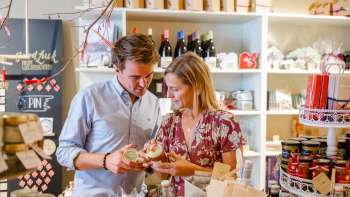 Ein Paar entdeckt regionale Spezialitäten im Hoi-Laden in Vaduz – authentische Produkte aus Liechtenstein hautnah erleben.