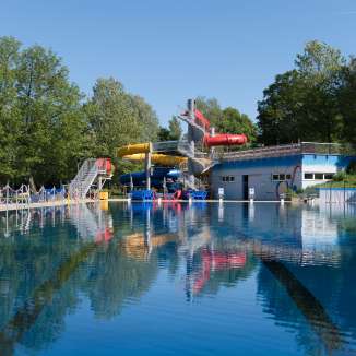 Schwimmbecken mit Wasserrutschen und Badehaus im Freibad Mühleholz in Vaduz