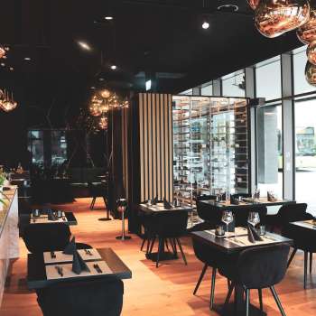 Modernes Restaurantinterieur mit eleganten schwarzen Tischen und Stühlen