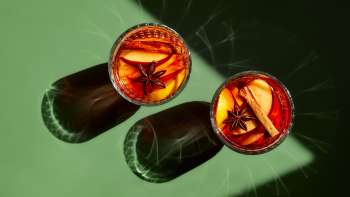 Mit Glühwein gefüllte Gläser auf einem grünen Tisch