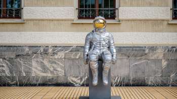 Silberne Astronautenskulptur „Raumableiter“ von Max Grüter vor dem Regierungsgebäude in Vaduz – moderne Kunst im öffentlichen Raum.