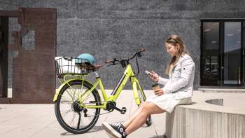 Frau sitzt neben einem E-Bike in Vaduz