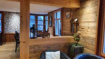 Einladender Innenbereich mit Holzwänden, stilvollem Sitzbereich und natürlicher Beleuchtung