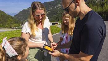 Familie trägt Minigolf-Punkte in eine Scorecard ein
