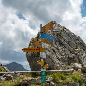 Wegweiser an der Pfälzerhütte mit Entfernungsangaben zu Wanderzielen in Liechtenstein.