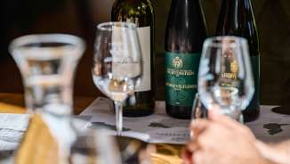 Nahaufnahme von Weingläsern und Weinflaschen der Hofkellerei Liechtenstein bei einer professionellen Weinverkostung mit Grüner Veltliner