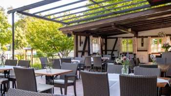 Einladender Außenbereich mit rustikalem Holzinterieur, geschmückten Tischen und blühenden Blumen