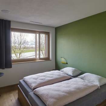 Zweibettzimmer mit grün gestrichener Wand in der Jugendherberge Schaan/Vaduz