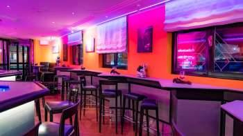 Blick in den Innenraum der Viva Bar, welche pink beleuchtet ist