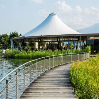 Steg am Badesee Grossabünt in Gamprin mit modernem Pavillon und Blick auf die Berge im Hintergrund