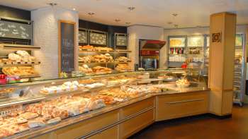 Blick auf den Verkaufsraum der Bäckerei Konditorei Amann mit gefüllter Theke und vielen Leckereien