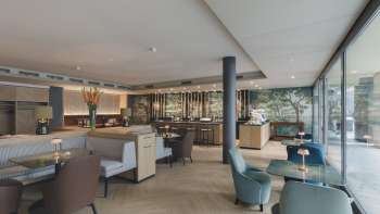 Modernes Restaurant mit stilvoller Inneneinrichtung, bequemen Sesseln und grossen Fenstern Modernes Restaurant mit stilvoller Inneneinrichtung, bequemen Sesseln und grossen Fenstern