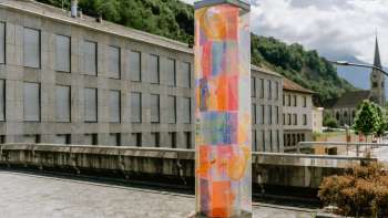 Farbenfrohe Jubiläumsstele in Vaduz mit leuchtenden Ornamenten, gestaltet von Künstlerin Evelyne Bermann.