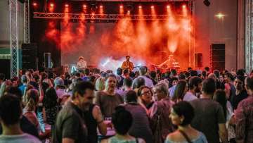 Konzert der Band Baba Shrimps beim FL1.LIFE Festival mit roter Bühnenbeleuchtung und großem Publikum