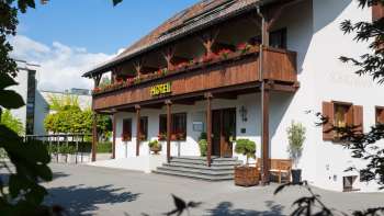 Aussenansicht des Restaurants Vivid mit traditioneller Fassade, Holzbalkon und blühenden Blumenkästen