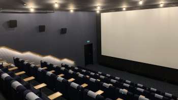 lick auf die große Kinoleinwand im Skino Schaan, mit Reihen bequemer Sitze in dunklem Design.