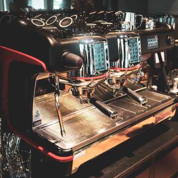 Kaffeemaschine im Restaurant mit glänzender Edelstahloberfläche und roten Akzenten