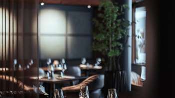 Modernes Restaurant mit stilvoller Inneneinrichtung, bequemen Sesseln und grossen Fenstern