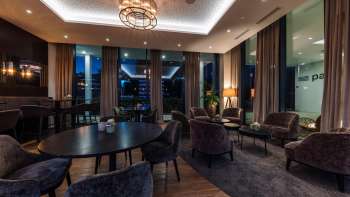  Innenbereich des Restaurants mit modernen Holztischen, bequemen Stühlen und stimmungsvoller Beleuchtung.