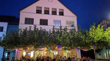 Stimmungsvolle Abendaufnahme des St. Martins Pub mit beleuchteter Terrasse und bunten Lichterketten