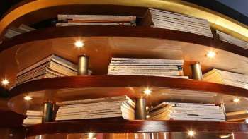 Holzregal mit illuminierten Büchern als Deckenverkleidung