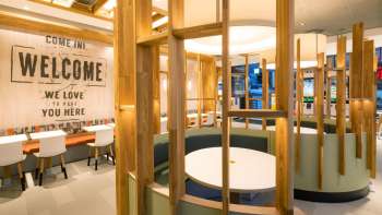 Innenaufnahme des modern eingerichteten McDonald's mit verschiedenen Holzelementen