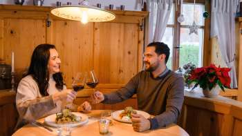 Paar beim Abendessen in gemütlicher Holzstube im Gasthof Au