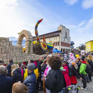 Fasnachtswagen und verkleidete Menschen beim großen Umzug in Vaduz, Liechtenstein.