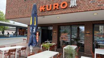 Aussenansicht des Restaurant Kuro mit Wein Tischen im Aussenbereich im Vordergrund