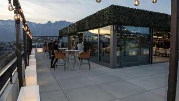 Rooftop-Terrasse des Casino Royal Restaurants mit Blick auf die umliegende Berglandschaft bei Abenddämmerung