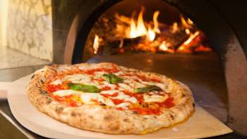 Detailaufnahme einer Pizza vor einem Pizzaofen der Ristorante Pizzeria Sapori