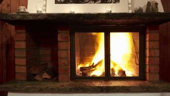 Warmer Kamin mit brennendem Holz und stimmungsvollem Licht