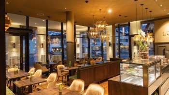 Elegantes Café mit gemütlichen Sitzbereichen, stilvollen Möbeln und warmem Lichtambiente