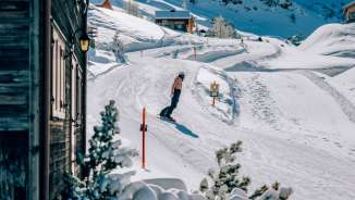 Snowboardfahrer geniesst sonnigen Tag auf den verschneiten Pisten in Malbun in Liechtenstein